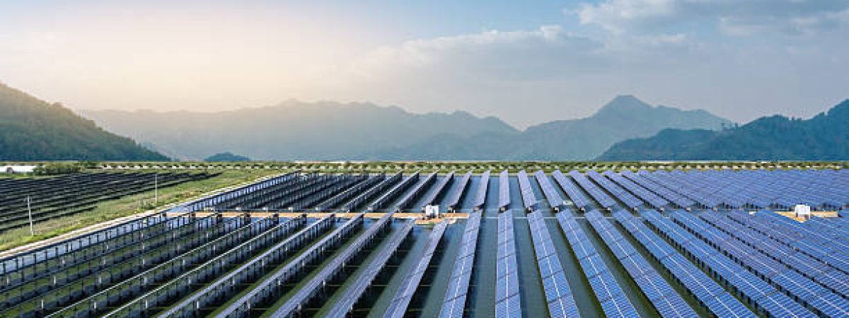 Expansive Solar Panel Array Amidst Serene Mountain Landscape